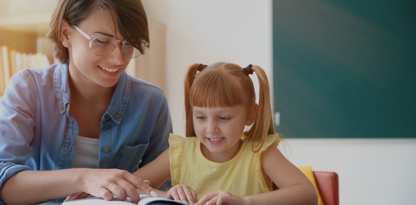 Male tutor sitting at table with student